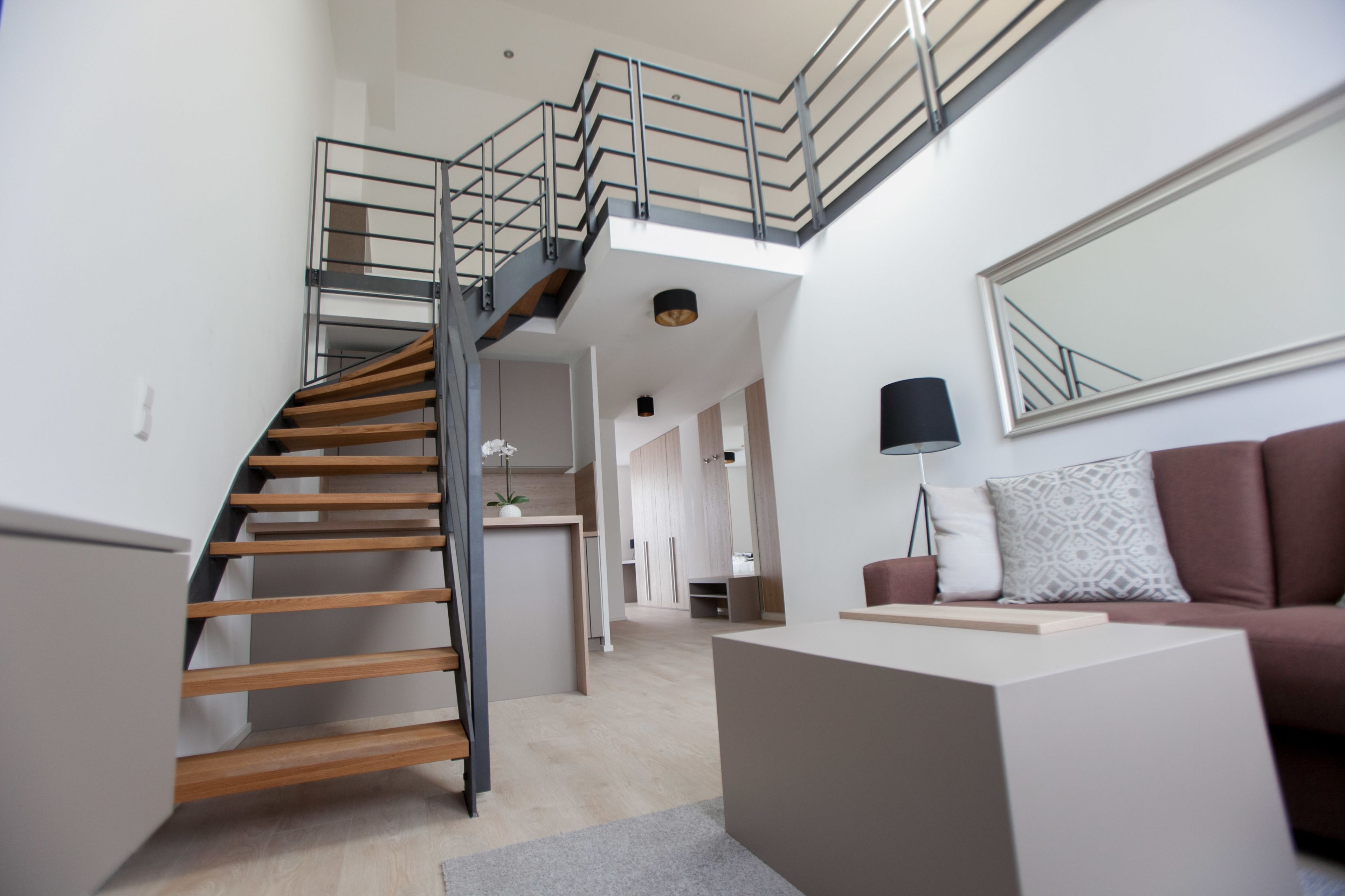 Un interior moderno con una escalera, un sofá y un comedor.