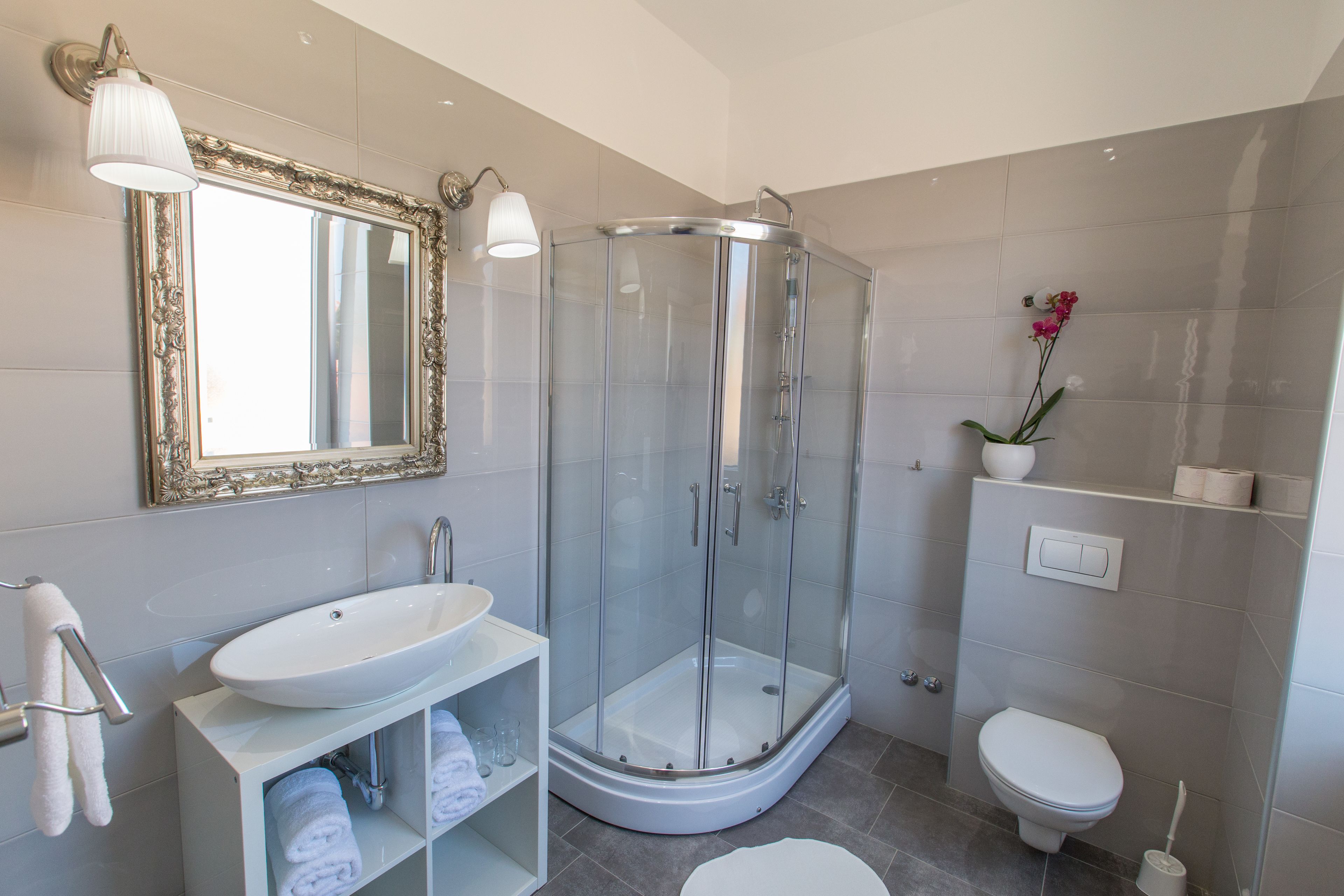 Un bagno moderno con doccia vetrata, lavandino bianco e water.