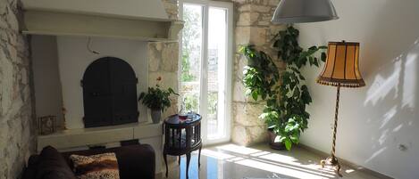 A living room with a stone fireplace, a sofa, a coffee table, and a lamp.
