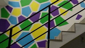 A staircase with a colorful mosaic wall. - Blum Hotel (Lviv)