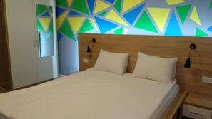 A bed with a wooden headboard, two pillows, and a bedside table with a lamp. - Blum Hotel (Lviv)