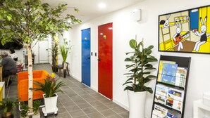A hotel lobby with a modern design, featuring a reception desk, seating areas, and a large plant. - 24 Guesthouse Jeonju (Jeonju)