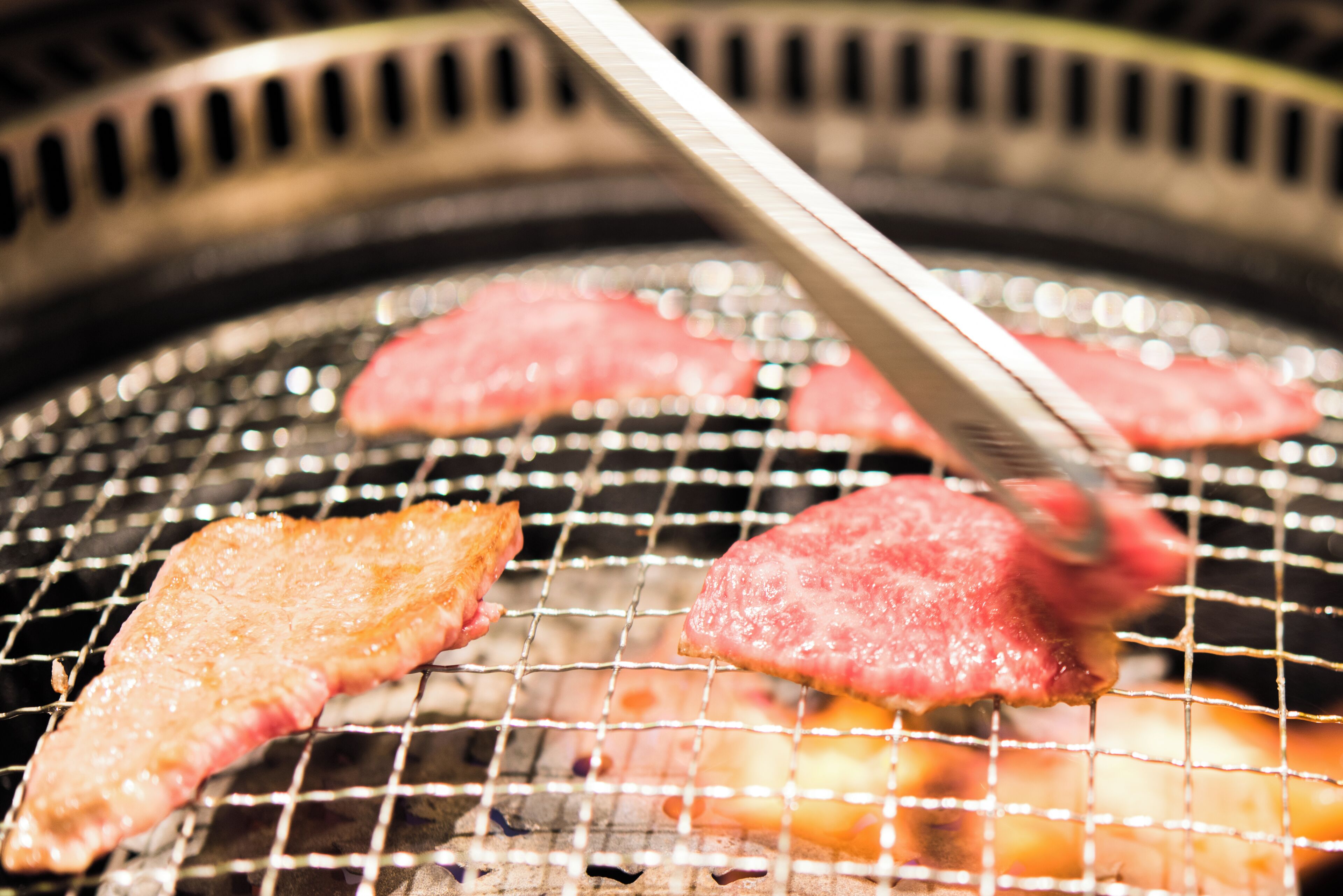 Una parrilla con carne asándose.