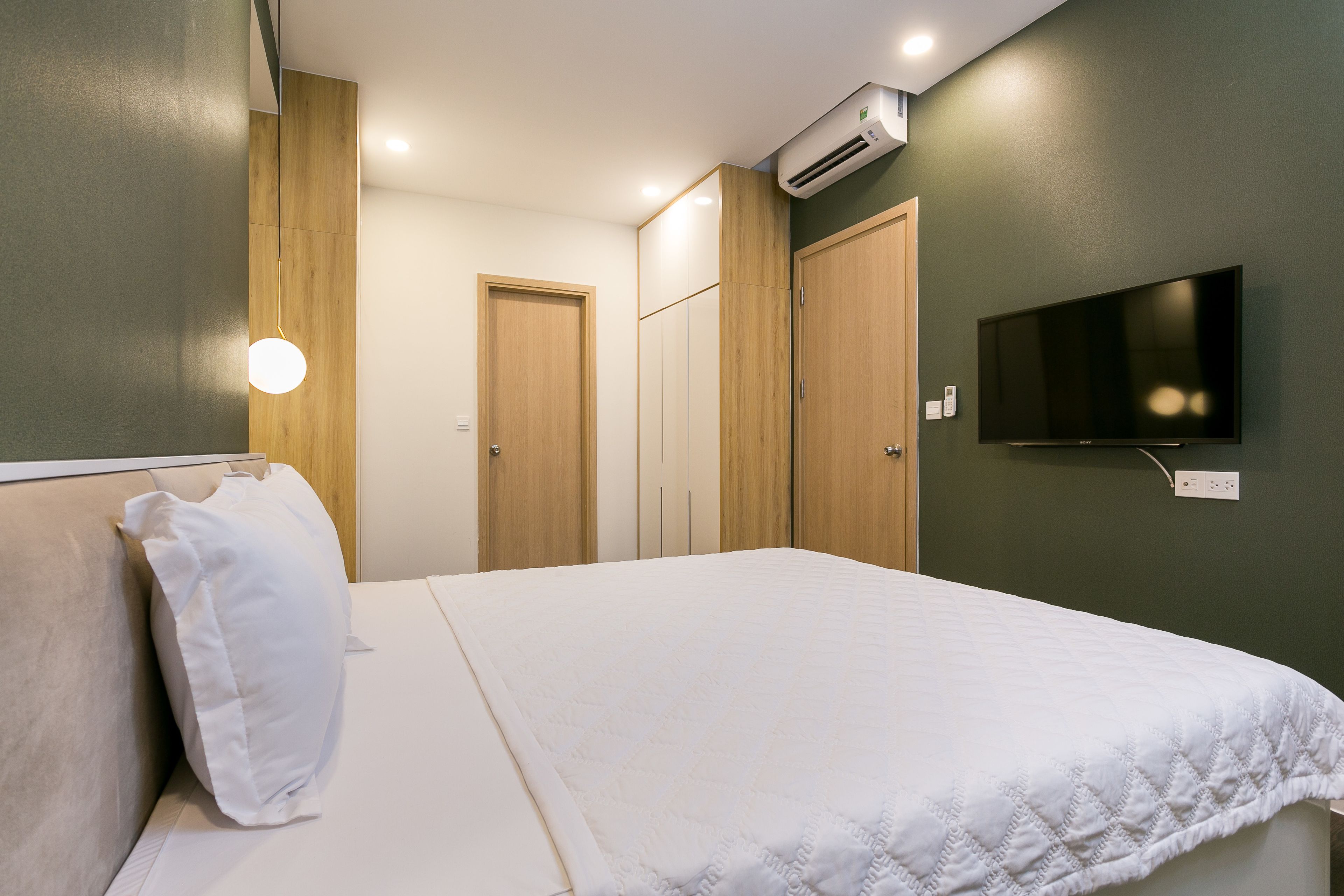 A bedroom with a bed, a TV, and a wardrobe.