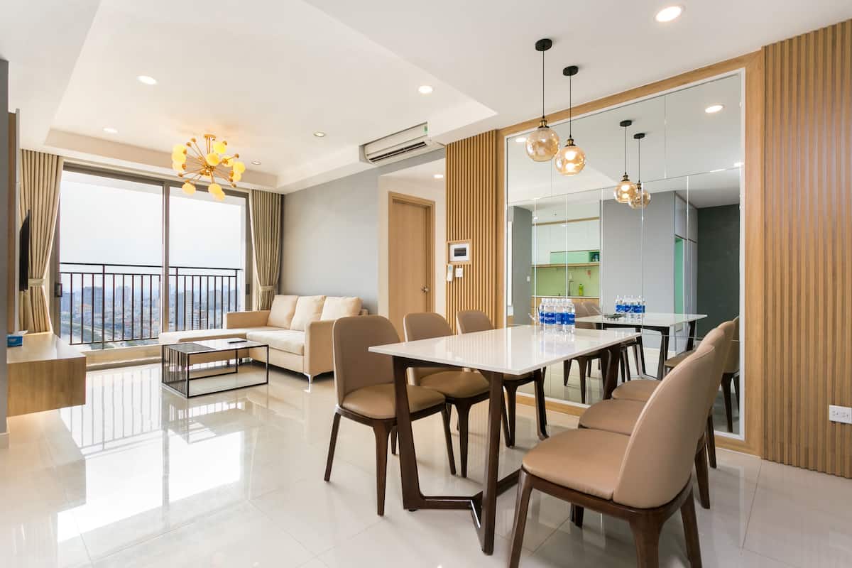 Une chambre d’hôtel moderne dotée d’un coin repas, d’un canapé et offrant une vue sur la ville.