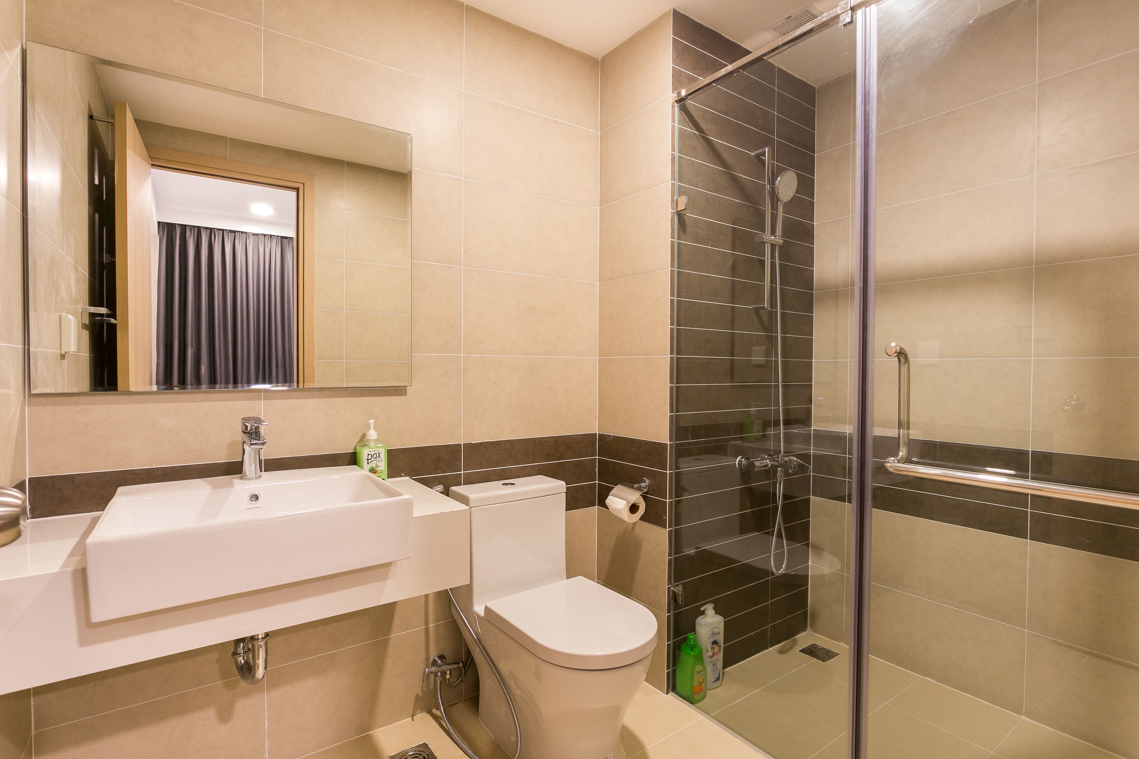 A modern bathroom with a sink, toilet, and glass-enclosed shower.