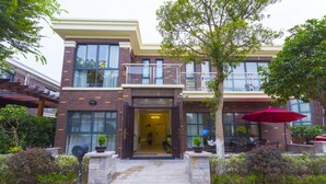 Un immeuble de deux étages avec une façade en briques, de grandes fenêtres et un balcon.