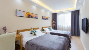 Habitación de hotel con dos camas, un escritorio, una silla, un televisor y obras de arte en las paredes.