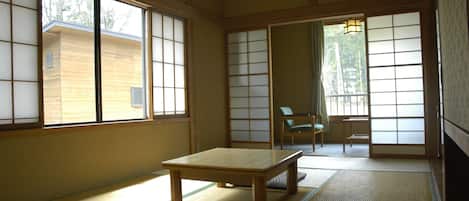 A traditional Japanese room with tatami flooring, a low wooden table, and sliding shoji doors.