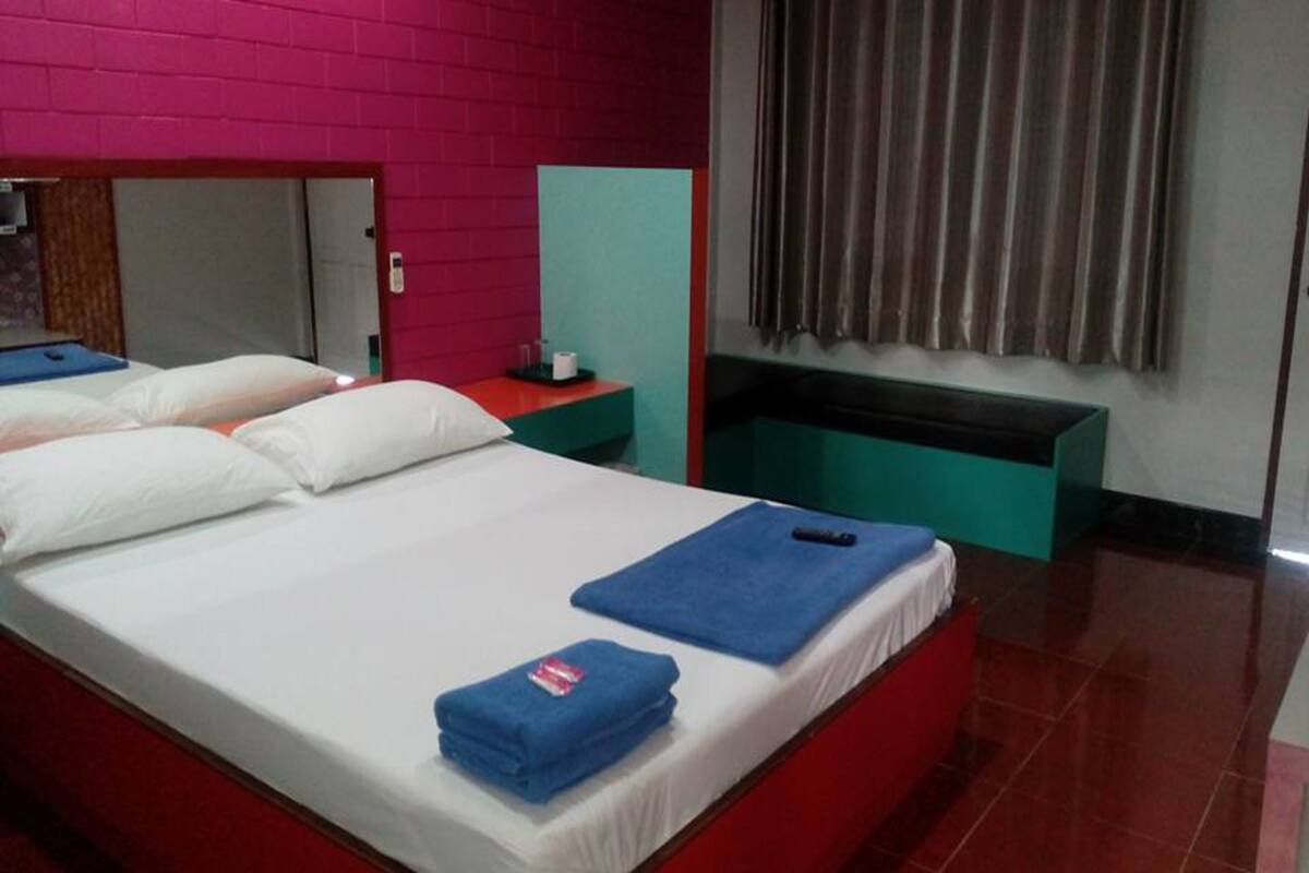 Ein Hotelzimmer mit Bett, Schreibtisch und Spiegel.