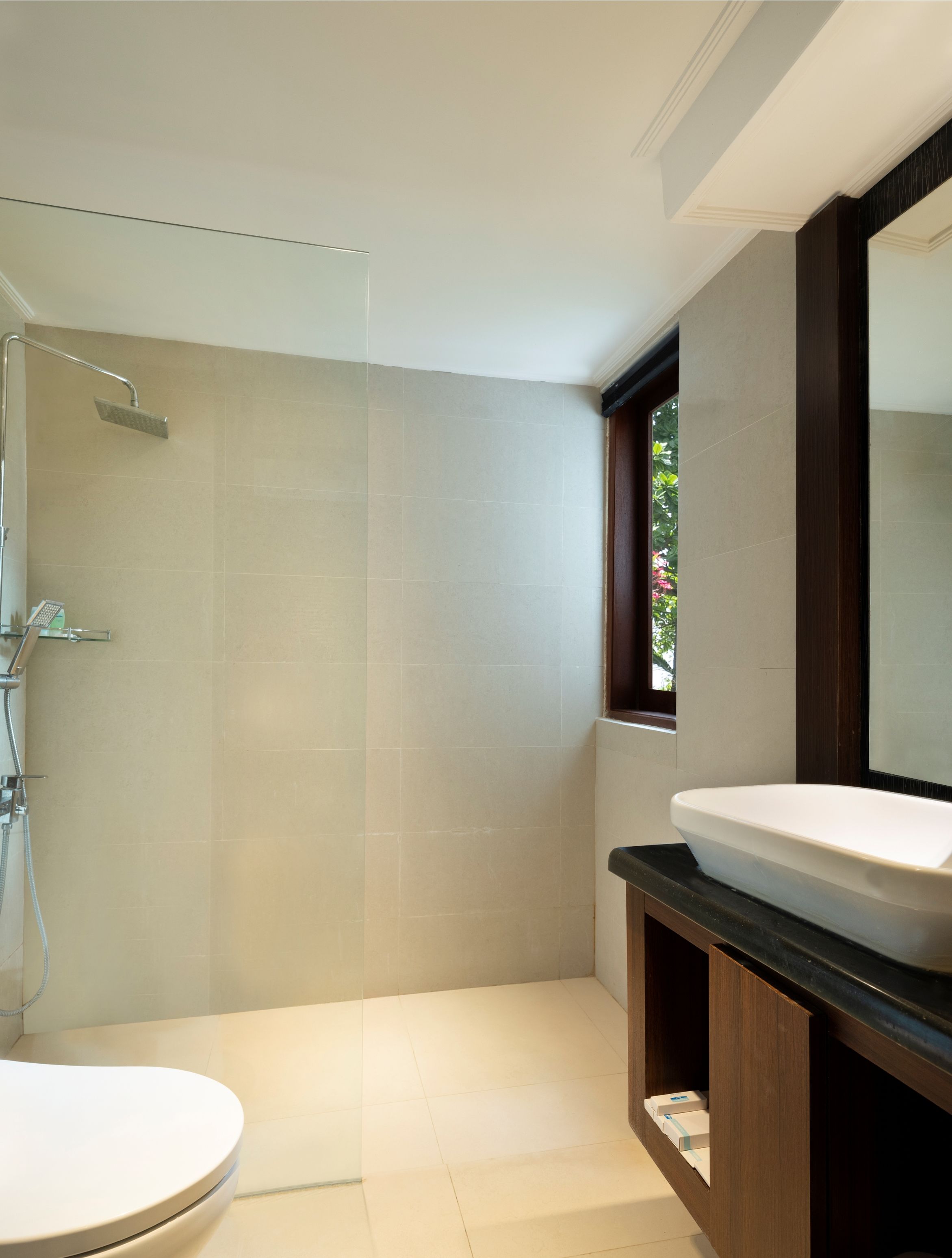 A modern bathroom with a shower, toilet, and vanity.