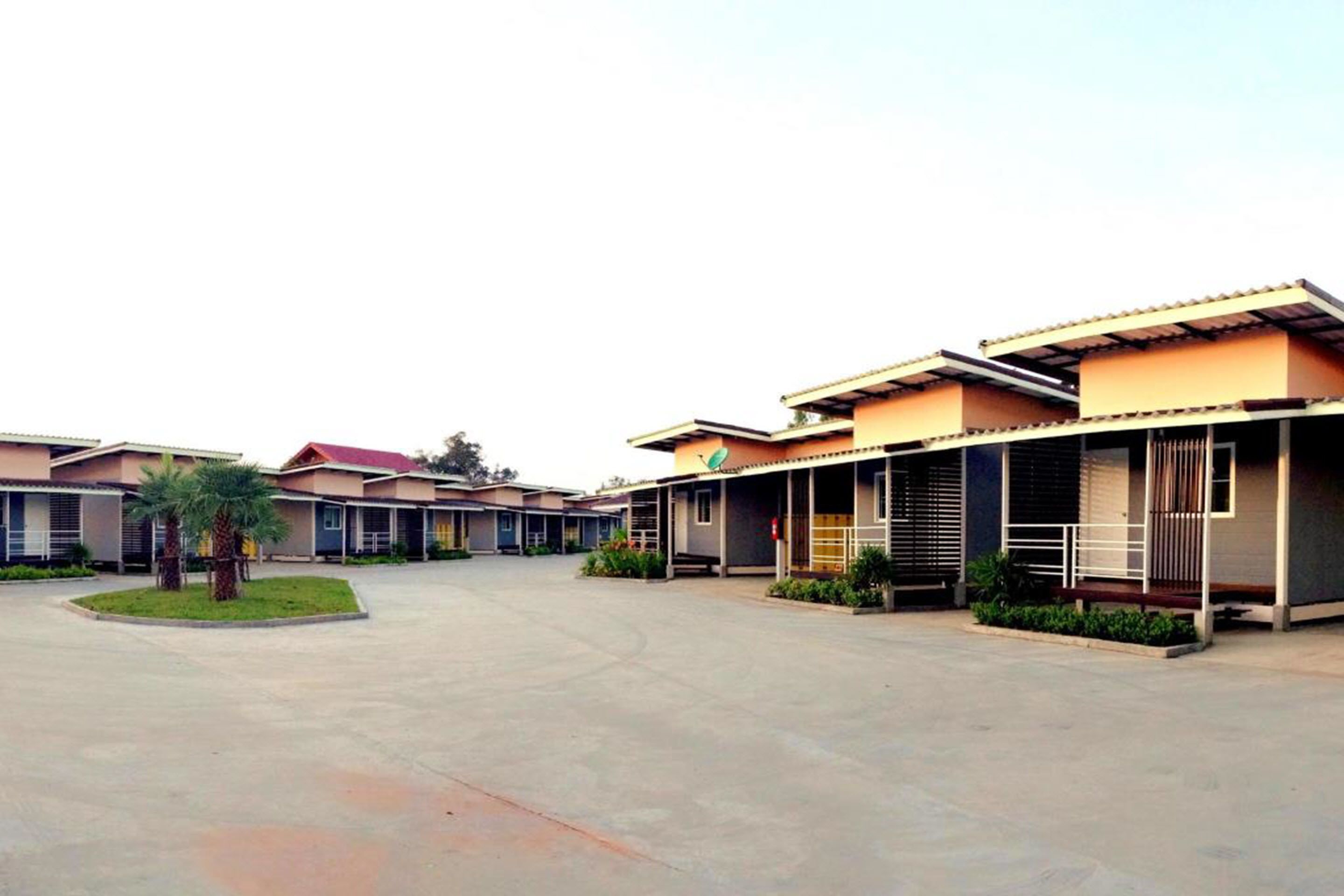 A hotel with multiple buildings, a central courtyard, and a small garden area.