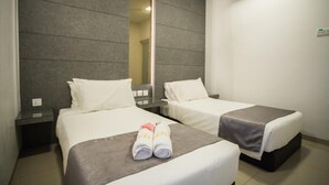 A hotel room with two single beds, a large mirror, an air conditioning unit, and a bedside table with a lamp. - IM 96 Villa (Kuantan)