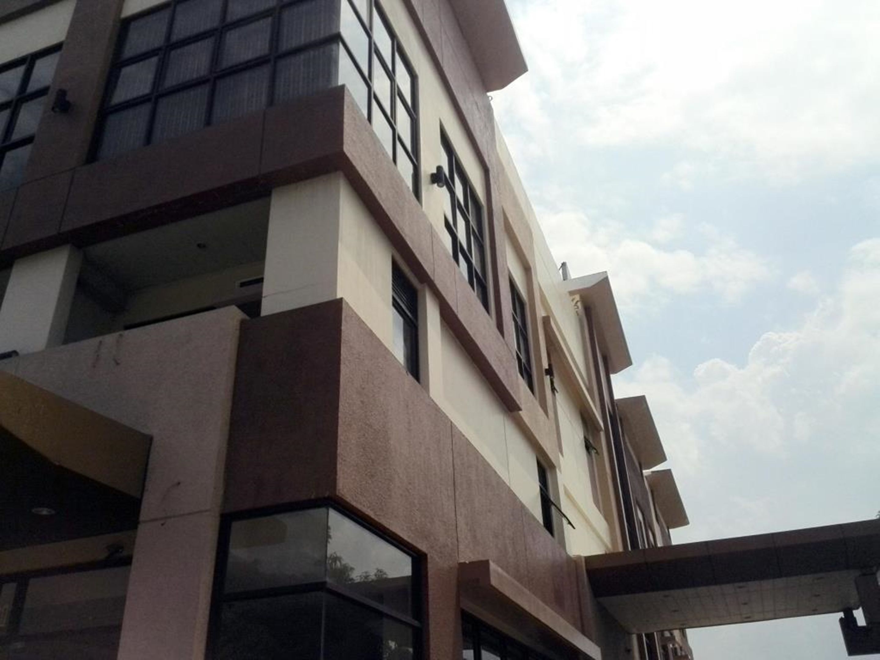 Um edifício de vários andares com arquitetura moderna, caracterizado por janelas amplas e um telhado plano.