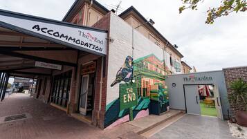 Un edificio con un mural de un ave y las palabras 'The End' en la pared.
