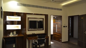 Een moderne kantoorruimte met een bureau, stoel en een wandgemonteerde televisie.