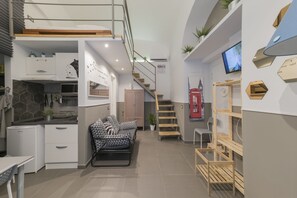 A modern interior with a kitchen, dining area, and a staircase leading to an upper level. - La Casa di Ulisse (Naples)