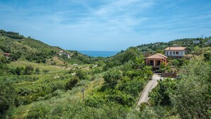 A hillside village with houses, a road, and a view of the sea. - Affittacamere Il Melograno (Pollica)