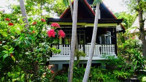 A house surrounded by lush greenery and red flowers. - Starbay Samui (Koh Samui)