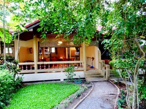 A house with a porch, a small garden, and a pathway leading to the entrance.