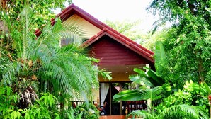 A house surrounded by lush greenery, with a red roof and a visible door. - Starbay Samui (Koh Samui)
