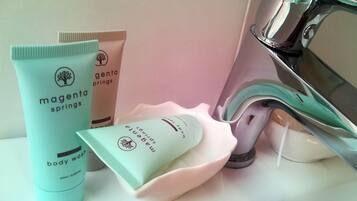 Toiletries including body wash and shampoo on a bathroom counter.
