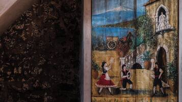 Una escalera conduce a una habitación con un mural que representa una escena histórica.