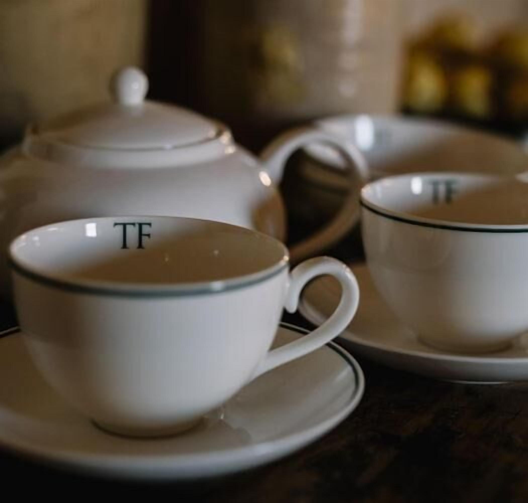 A tea set with a teapot and two cups on saucers.
