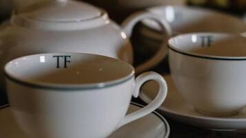 A tea set with a teapot and two cups on saucers.