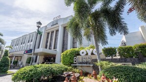 Een hotel met een opvallend bord waarop 'OYO BLISS HOTEL' staat, en een goed onderhouden tuin met decoratieve lantaarns.