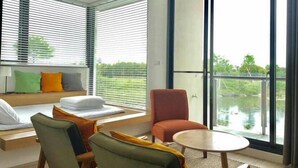 A modern living room with a sofa set, a round table, and a red chair. - Missy House (Wujie)