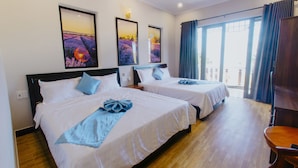 A hotel room with two beds, a wooden floor, and large windows with curtains. - Home River Villa (Da Nang)