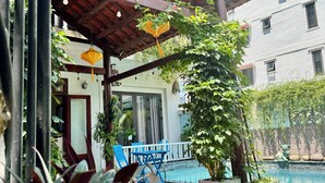 A wooden pergola with a sign reading "HOME RIVER VILLA" above a pool area. - Home River Villa (Da Nang)