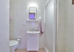 Ducha, artículos de tocador gratuitos, pantuflas, toallas
