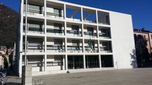 Ein modernes, mehrgeschossiges Gebäude mit schlichter Fassade, großen Fenstern und einem zentralen Eingang.