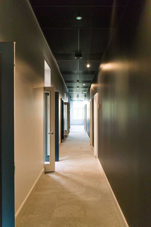 A long, narrow hallway with doors on both sides leading to individual rooms. - Park Hotell Viljandi (Viljandi)