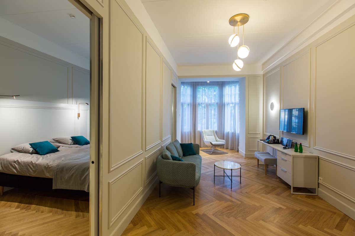 Une chambre d’hôtel moderne équipée d’un lit, d’un canapé, d’un bureau et d’une télévision.