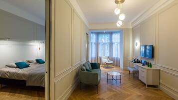 Una habitación de hotel moderna con cama, sofá, escritorio y televisor.