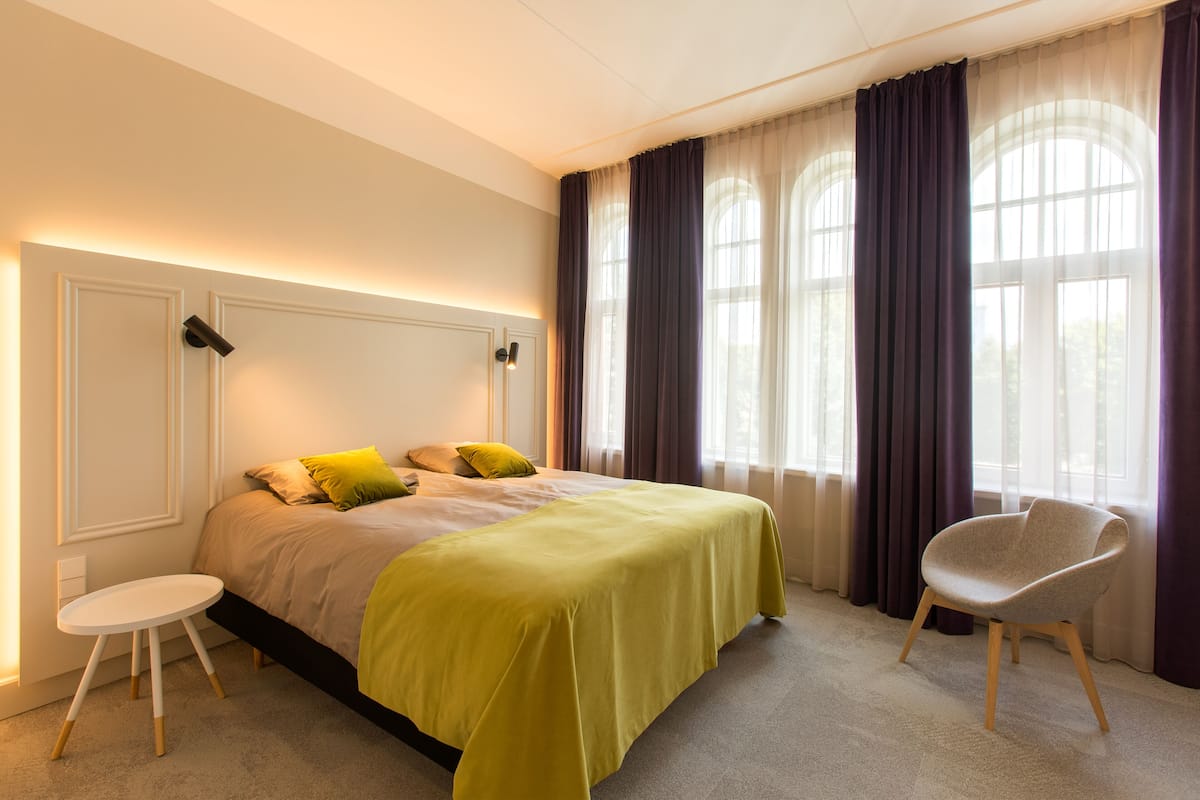 Une chambre à coucher avec un lit, une chaise et une petite table.