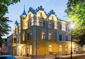 Un edificio histórico con torreta y múltiples ventanas, probablemente un hotel o edificio público.