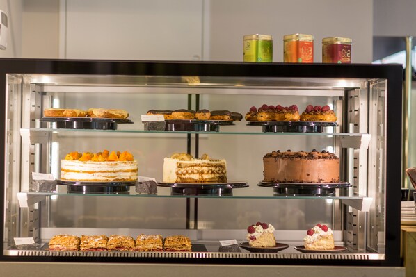 Una vitrina con varios pasteles y dulces.