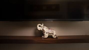 A wooden shelf with a decorative elephant figurine.