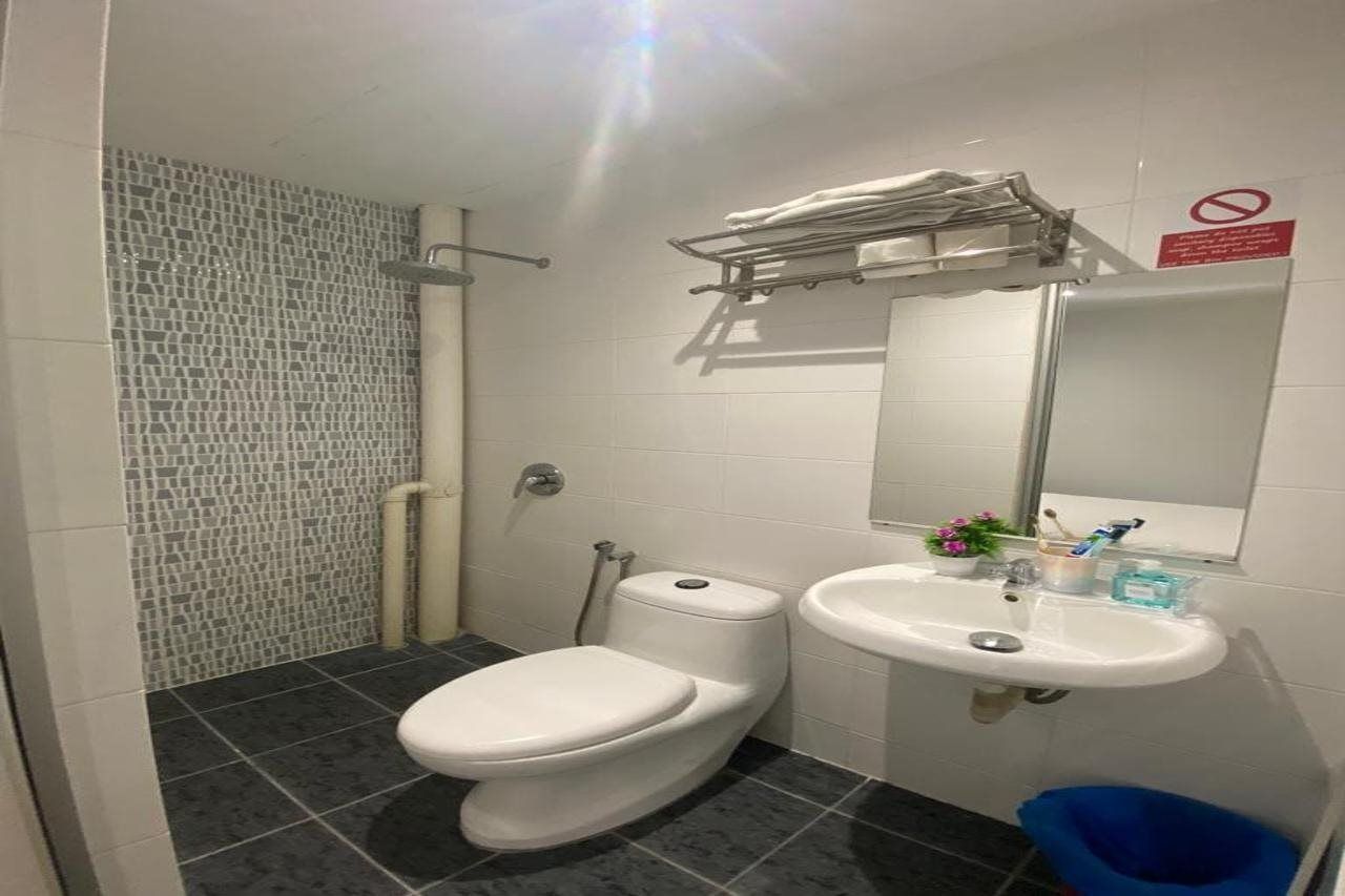 A bathroom with a toilet, sink, and shower.