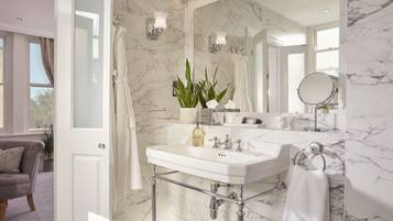 A bathroom with a white marble sink, a large mirror, and a shower curtain.