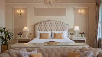 Une chambre à coucher luxueuse avec une tête de lit capitonnée, une table de chevet en verre, un canapé moelleux et un lustre.