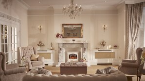 A luxurious living room with a fireplace, elegant furniture, and decorative elements.