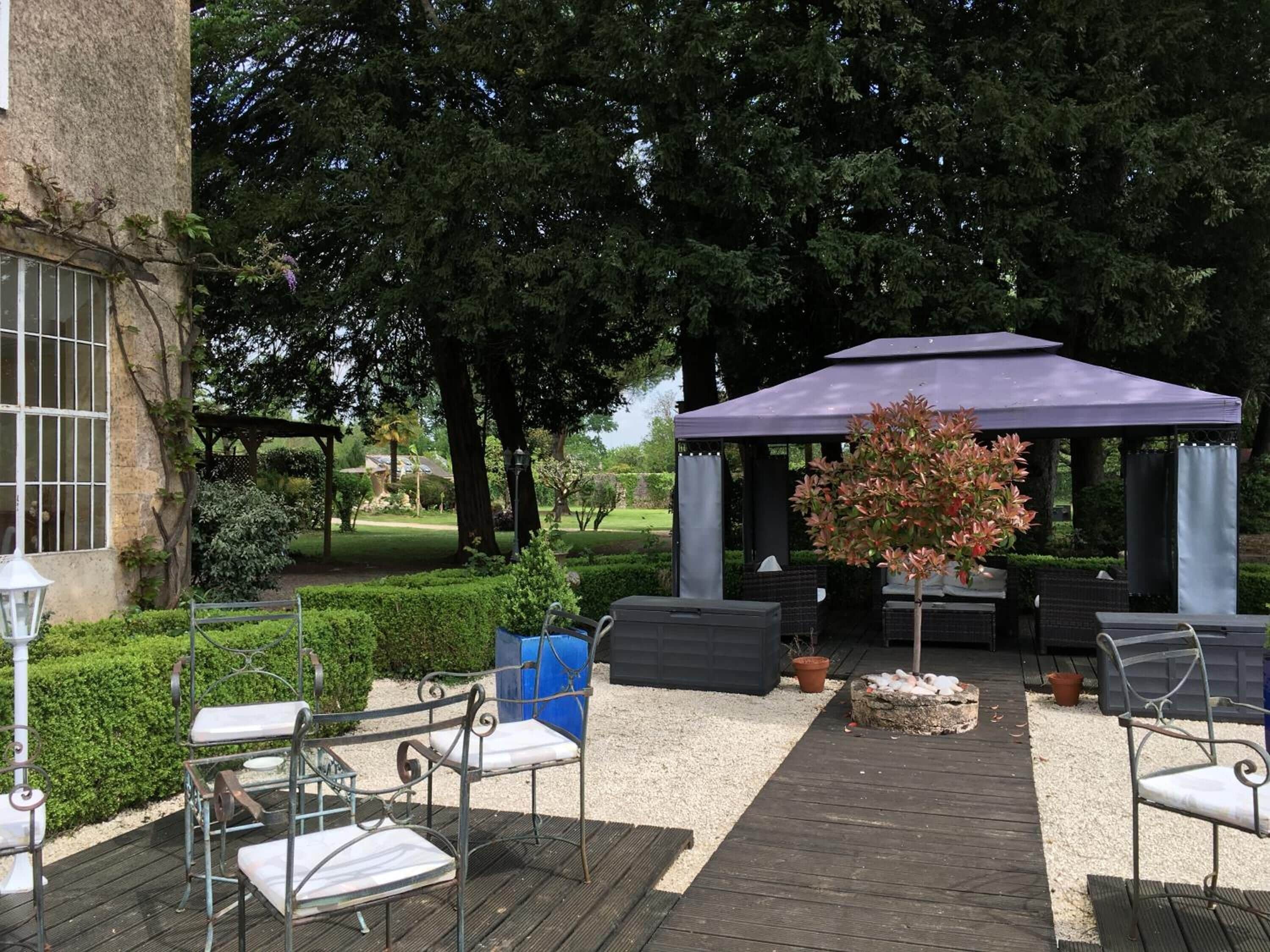 Un espace extérieur aménagé avec des sièges, un belvédère et un jardin.