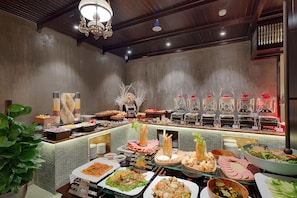 A buffet with various food items and a decorative plant. - Little Riverside. A Luxury Hotel & Spa (Da Nang)