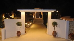 A well-lit entrance with a covered walkway leading to a staircase. - Konaki Hotel & SPA (Aristotelis)