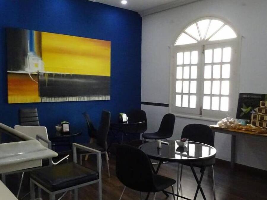 Un salón de conferencias con pared azul decorativa, un ventanal grande y una mesa con aperitivos.